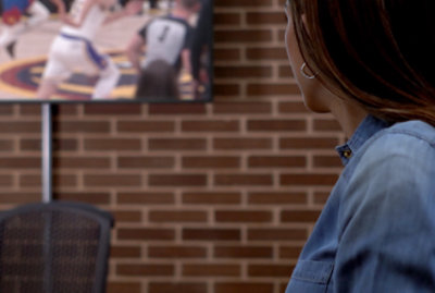 A woman watching a television.