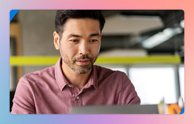 A close-up of a man's face as he looks at a laptop screen.