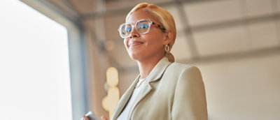 אישה מרכיבה משקפיים ולובשת חליפה.