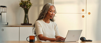 אדם יושב ליד שולחן עבודה ומקליד במחשב נישא.