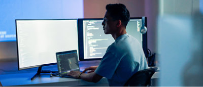 אדם היושב ליד שולחן עבודה עם מחשב נישא.