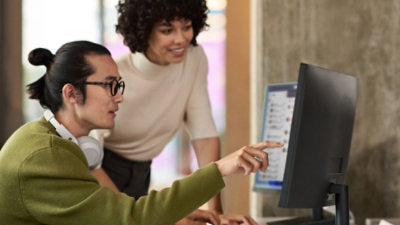 Two person looking at the desktop.