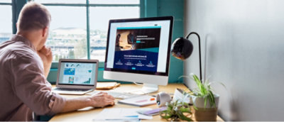 使用膝上型電腦和顯示器工作的人。