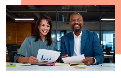 A Man and woman holding papers and smiling