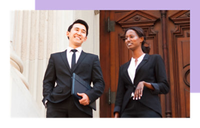 A Man and woman holding laptops and standing
