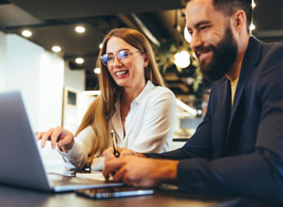 A man and woman looking at laptop and laughing