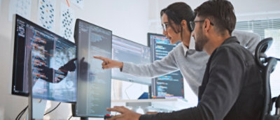 A Man and women looking at monitor screen and discussing