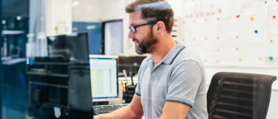 A man sitting and working infront of system.