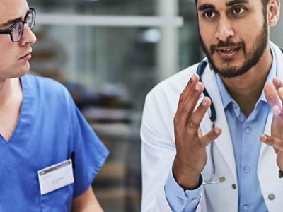 A man as a doctor explaining somtheing to a nurse.