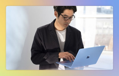 A man holding a laptop and typing.