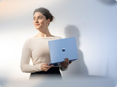 A women holding a laptop and looking somewhere.