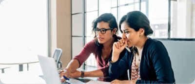 Two women looking at a laptop.