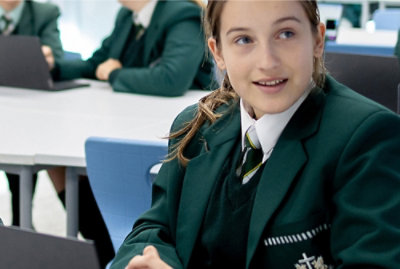 A girl sitting on a chair smiling.