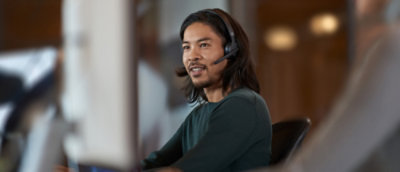 A person wearing headphones looking in to desktop