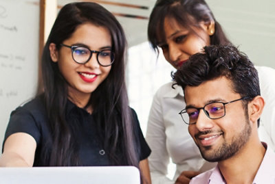 A group of people looking at a laptop.