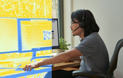 A person wearing headphones and looking at desktop.