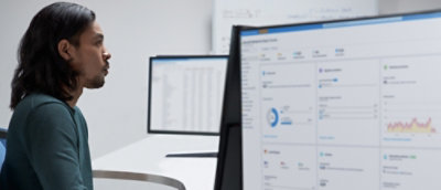 A person looking at a two desktop big screen.