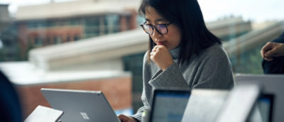 A women seriously looking at computer screen.