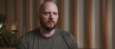 A person with beard seriously looking some where.