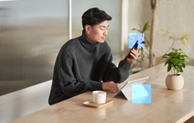 A man sitting in the office environment looking at the smartphone
