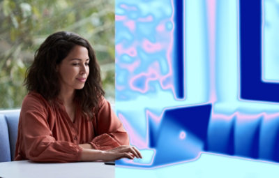 A woman sitting in office environment and looking at the screen