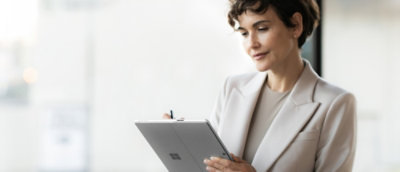 A person in a suit holding a rectangular device.
