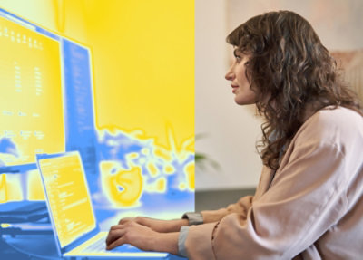 A women working with a laptop and desktop
