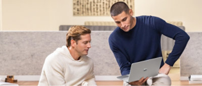 A man sitting on a chair using a laptop.