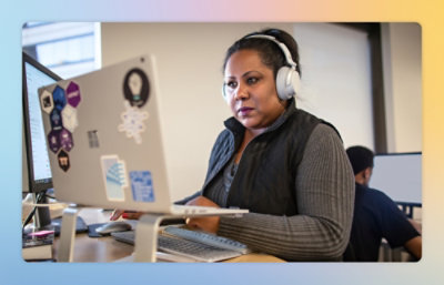 A person wearing headphones and using a computer at a desk.