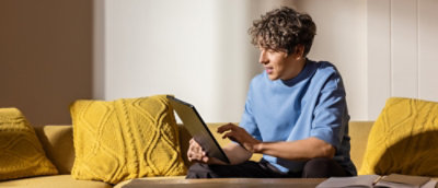 A person sitting on a couch using a laptop.