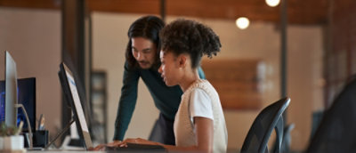A man and woman looking at a computer.