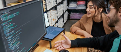 En kvinde sidder ved et bord med en mand i en sort skjorte.