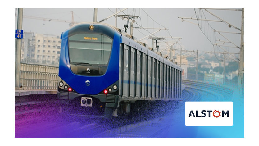 Un train bleu circule sur des rails à proximité d'une ville animée.