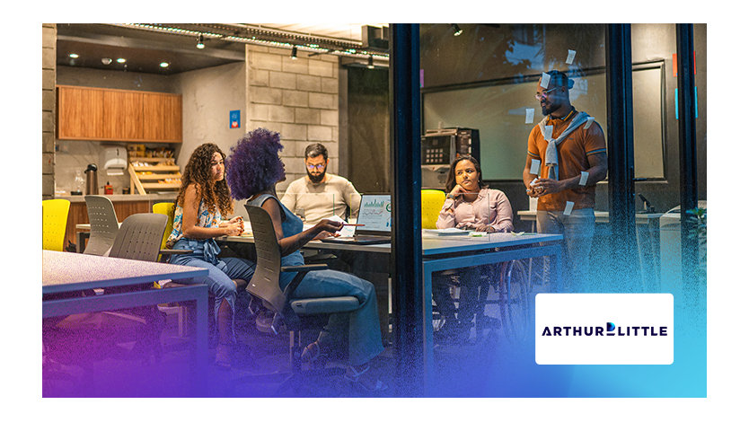 Employés travaillant à des bureaux dans un espace de bureau lumineux, entourés de murs en verre.