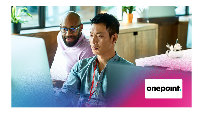 Deux hommes sont assis à un bureau, travaillant ensemble sur un ordinateur.