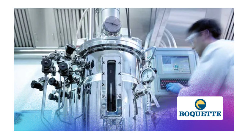 Un homme en blouse de laboratoire travaille sur une machine dans un environnement de recherche scientifique.