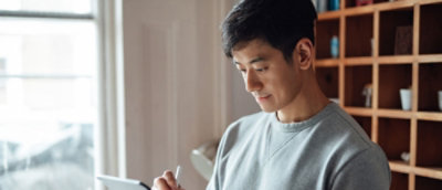 Un hombre escribiendo en un papel.