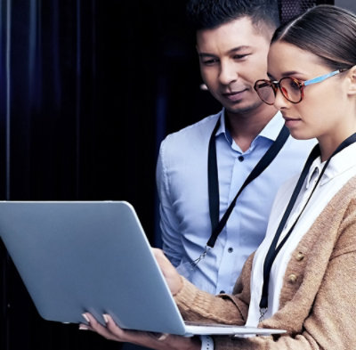 A man and woman looking at a laptop.