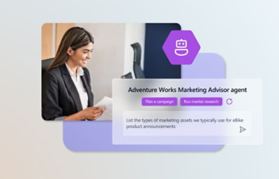 一位身着套装的女性坐在办公桌前，对着电脑屏幕露出微笑。