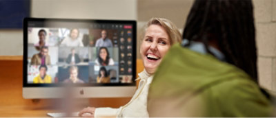 Una mujer sonríe ante la pantalla de un ordenador.