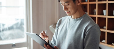 一名男士手拿着平板电脑和手写笔。