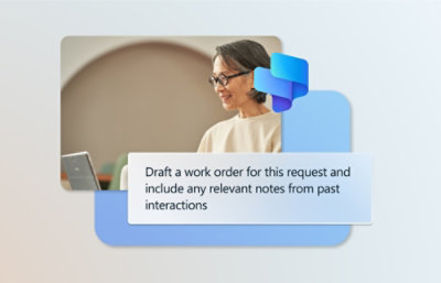 A woman with glasses smiling and looking at a laptop while drafting a work order.