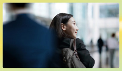 Person with a backpack walking through a modern office building.