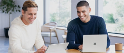 A couple of men looking at a laptop.