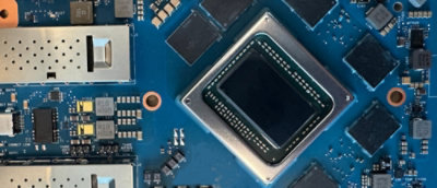 A close-up of a circuit board with a black square component.