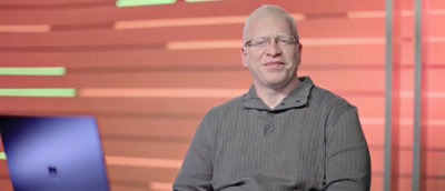 A man wearing glasses and a gray shirt.