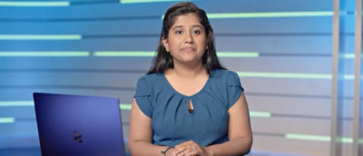 A woman sitting in front of a blue laptop