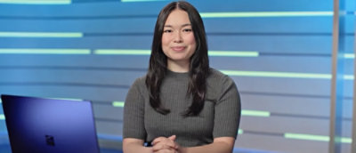A woman with long hair wearing a gray sweater.