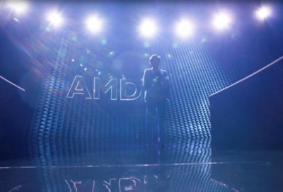 A man standing in dark in front of AMD logo