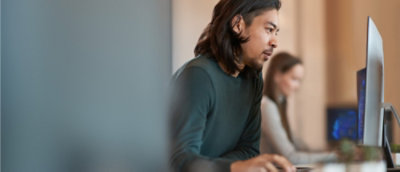A person with long hair working on the laptop